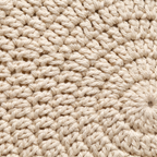 Extreme close-up of hand-crocheted cream cotton stitches showing the texture of genuine handwork